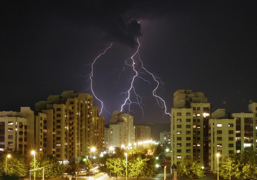 Lighting strikes from an ominous sky over apartment blocks in northern Bosnian town of Tuzla, on Tuesday, July 25, 2006. After a heat wave that has caused many forest fires and difficulties for elderl ...