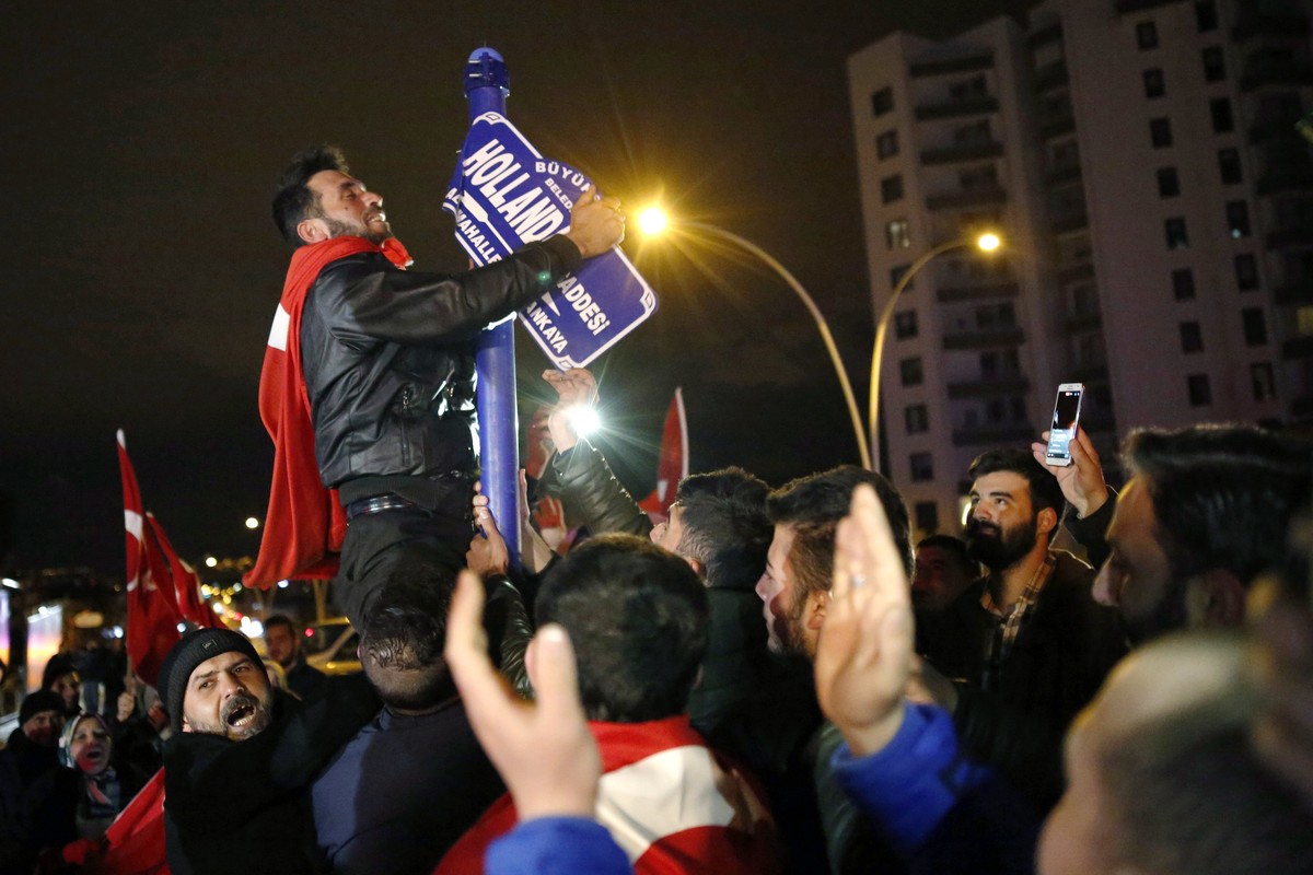 epa05843756 epa05843750 Supporters of Turkish President Recep Tayyip Erdogan try to remove the 'Hollanda' (Netherlands) street sign as they shout slogans against Netherlands and hold Turkish ...