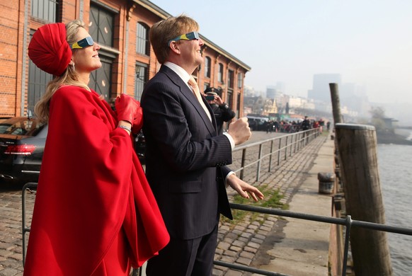epa04670828 Queen Maxima and King Willem-Alexander of the Netherlands look at the solar eclipse through special glasses at the Fish Market inÂ Hamburg, Germany, 20 March 2015. The royal couple is on a two-day working visit of Northern Germany. A Partial Solar Eclipse is seen in Europe, northern and eastern Asia and northern and western Africa on 20 March with the eclipse starting at 07:41 UTC and ending at 11:50 UTC.  EPA/CHRISTIANÂ CHARISIUS