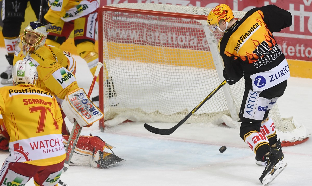 Lugano's Gregory Hofmann, right, scores the 2-1 goal against Biel's goalkeeper Jonas Hiller, left, during the preliminary round game of National League Swiss Championship between HC Lugano a ...