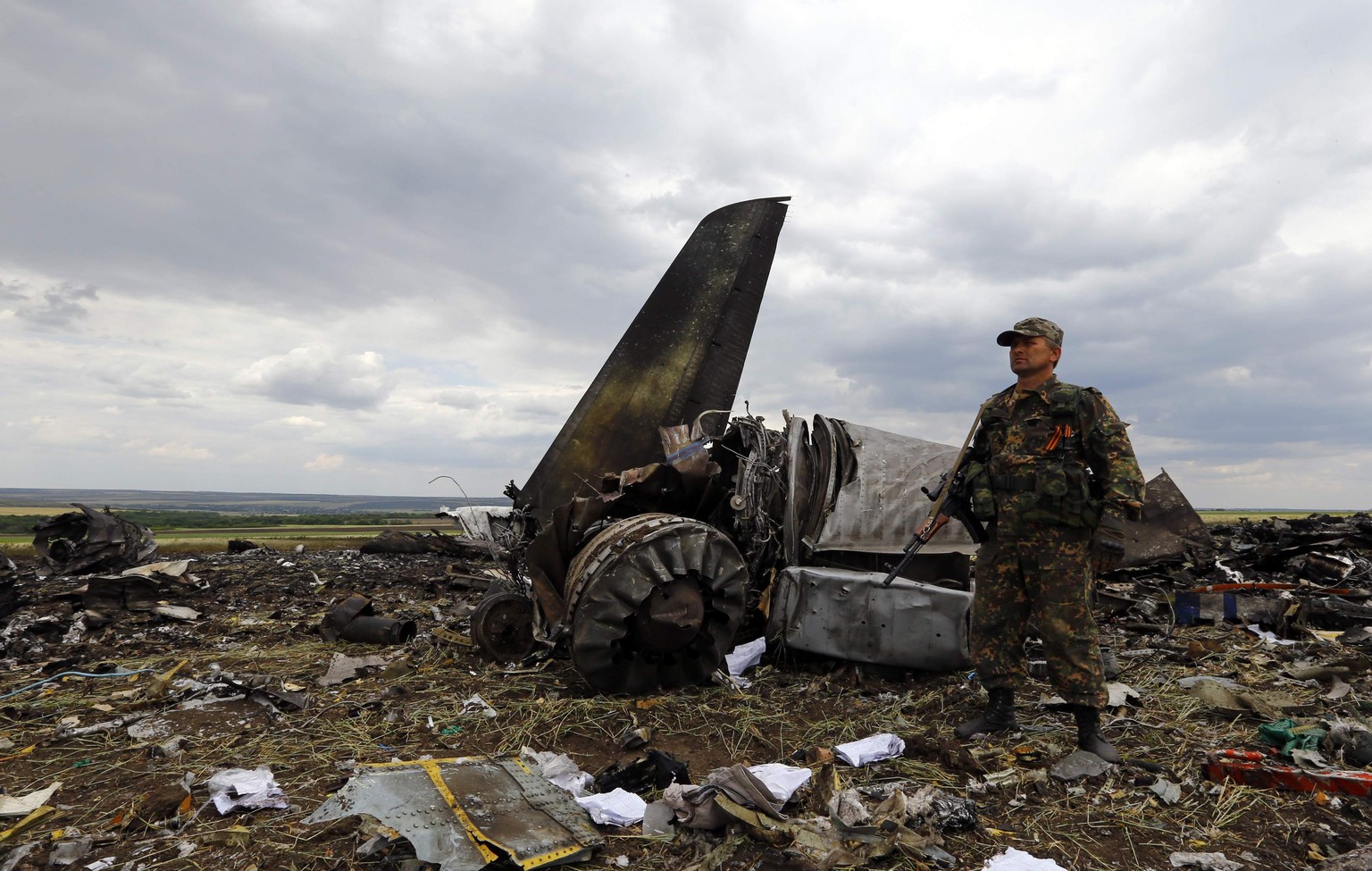 Ein prorussischer Separatist vor dem Wrack des abgeschossenen Flugzeugs.