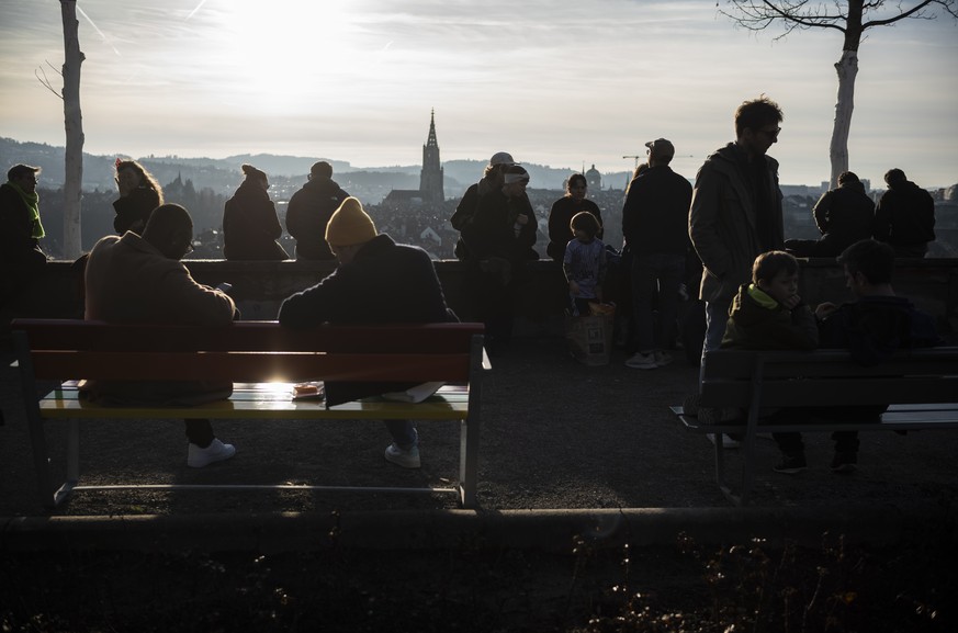 Spaziergaengerinnen und Spaziergaenger tummeln sich bei fuer die Jahreszeit ungewoehnlich warmen Temperaturen im Rosengarten und geniessen die Aussicht auf die Altstadt Berns mit Muenster und Bundesha ...