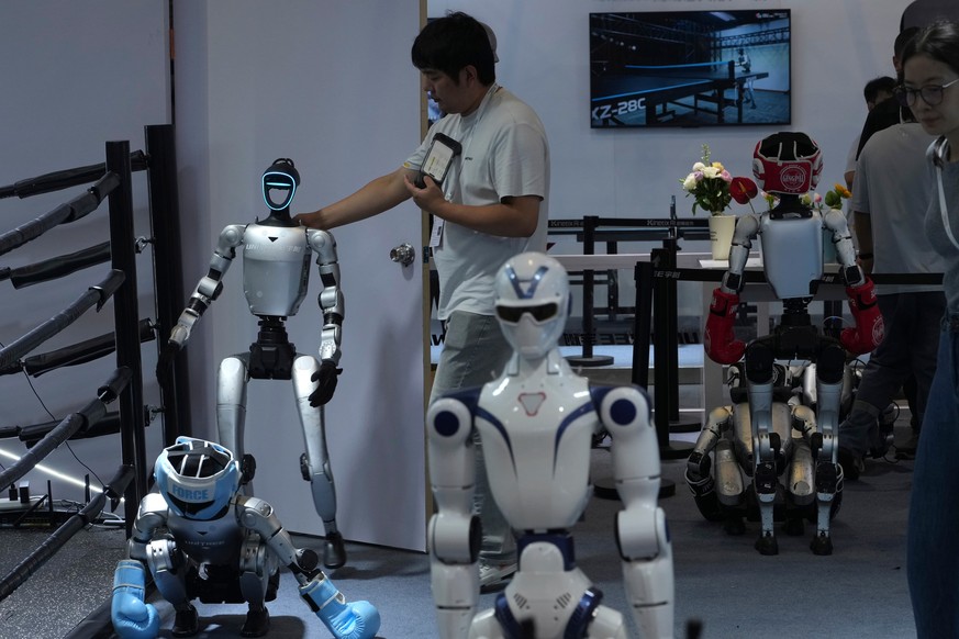 A worker gets a robot ready for demonstration at a booth for leading Chinese commercial humanoid robotics firm Unitree Robotics during the World AI Conference in Shanghai, China, on July 18, 2026. (AP ...