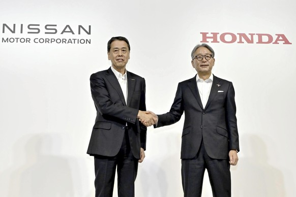 Nissan Chief Executive Makoto Uchida, left, and Honda Chief Executive Toshihiro Mibe shake hands during a joint news conference in Tokyo, Thursday, Aug. 1, 2024. Japanese automakers Nissan and Honda s ...