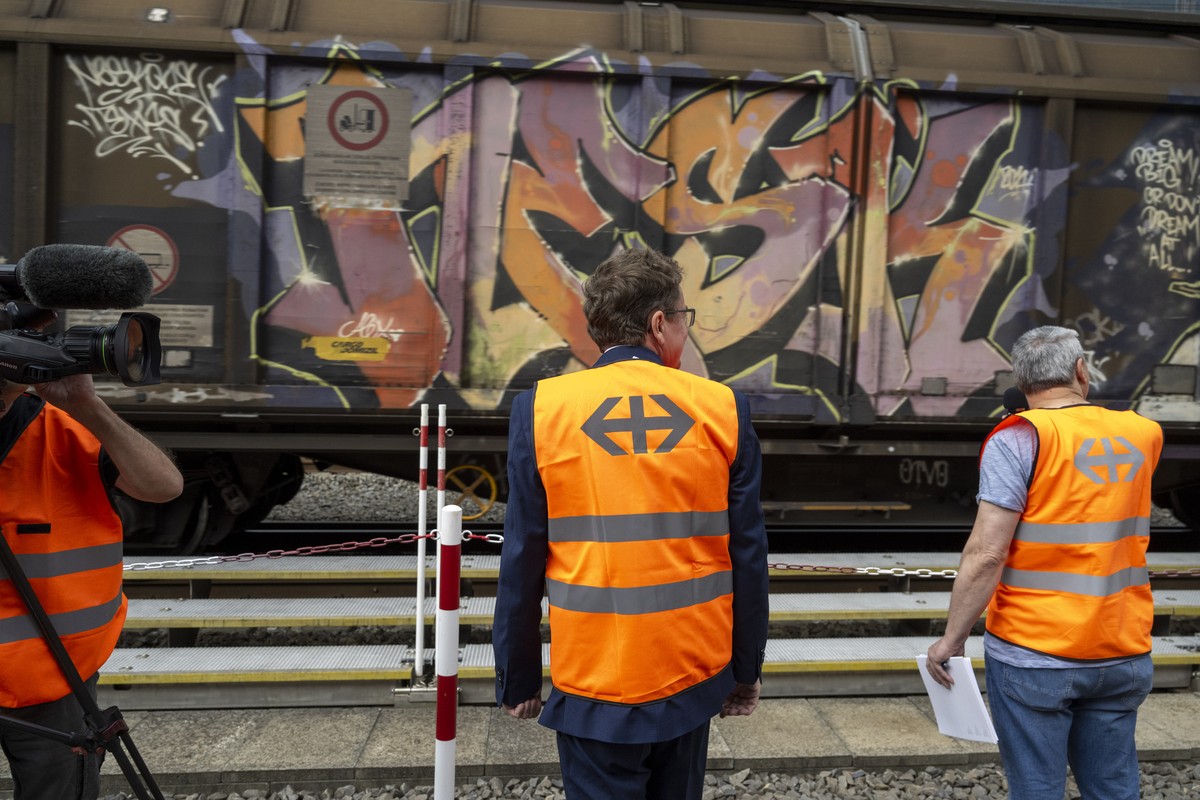 Der Bundesrat Albert Roesti, links, schaut einem Gueterzug nach, bei eiem Medientermin vor dem Tunnelportal Sued, anlaesslich einer Medienkonferenz zur Wiederinbetriebnahme des Gotthard-Basistunnels a ...