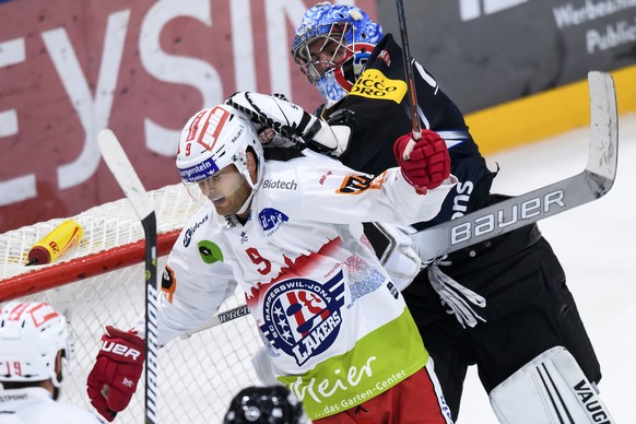 Fribourgs Goalie Reto Berra, rechts, kaempft gegen Rapperswils Casey Wellman, links, beim Eishockey Meisterschaftsspiel der National League A zwischen den HC Fribourg Gotteron und dem SC Rapperswil-Jo ...