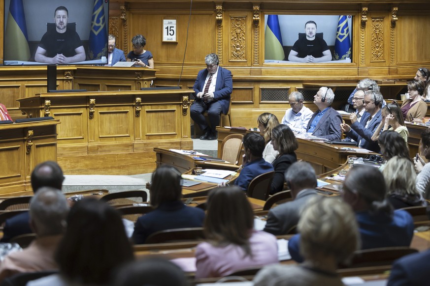 Ukrainian President Volodymyr Zelenskyy is displayed on a screen during his speech to the members of the Swiss parliament in Bern, Switzerland, Thursday, June 15, 2023. (Peter Klaunzer/Keystone via AP ...