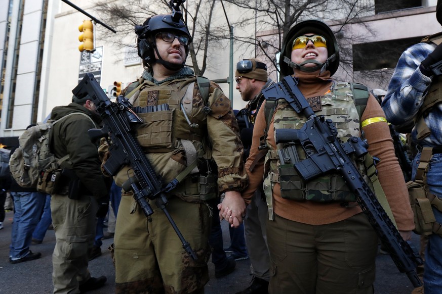 Demonstrators stand outside a security zone before a pro-gun rally, Monday, Jan. 20, 2020, in Richmond, Va. (AP Photo/Julio Cortez)