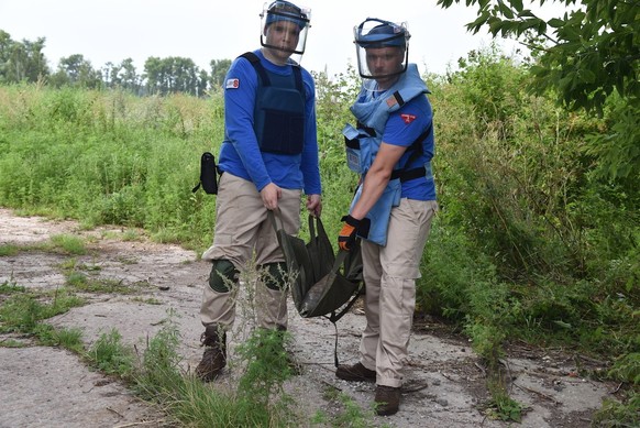 Dmijtro and an American specialist evacuate a shell.