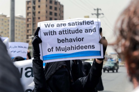 epa09461014 Afghan women hold placards during a pro-Taliban rally outside the Shaheed Rabbani Education University in Kabul, Afghanistan, 11 September 2021. The United States envoy for peace in Afghan ...