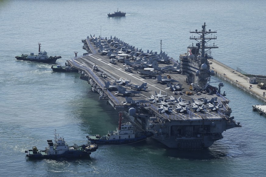 The U.S. carrier USS Ronald Reagan is escorted as it arrives in Busan, South Korea, Friday, Sept. 23, 2022. The nuclear-powered aircraft carrier arrived in Busan port on Friday ahead of the two countr ...
