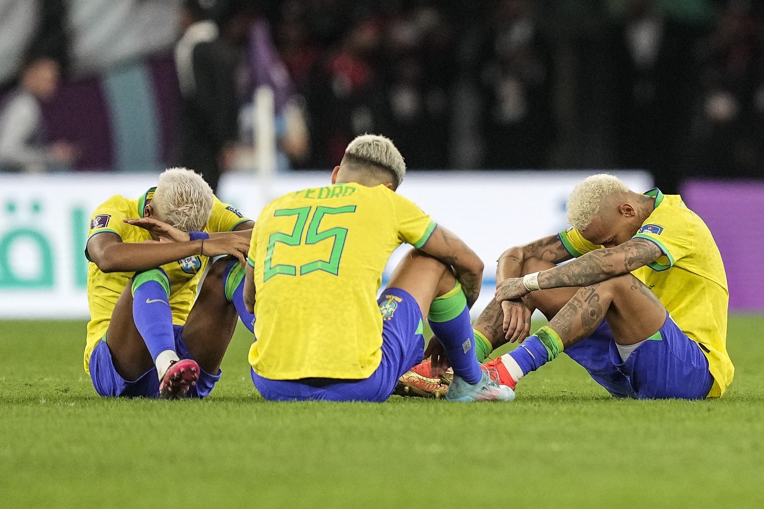 Brazil&#039;s Rodrygo, Brazil&#039;s Pedro and Brazil&#039;s Neymar, from right, sit on the pitch after losing the World Cup quarterfinal soccer match between Croatia and Brazil, at the Education City ...