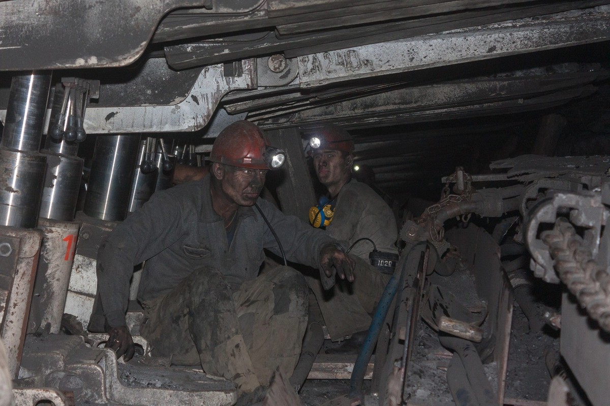 Donetsk, Ukraine - August, 16, 2013: Miners at work in cramped conditions underground excavation