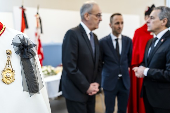 A mourning ornament is seen on a Federal ushers cloak as Swiss Federal President Guy Parmelin, left, speaks to Mathias Reynard, State Councillor and president of the Council of State of the Canton of  ...