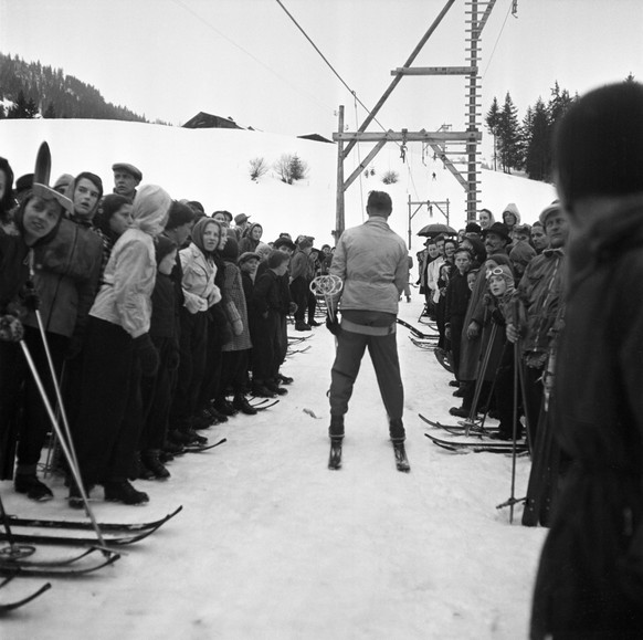 With a large crowd watching, a skier rides up onto Monts Chevreuils mountain with the ski-lift on the day of its inauguration, pictured on February 10, 1945 in Chateau-d&#039;Oex in the canton of Vaud ...