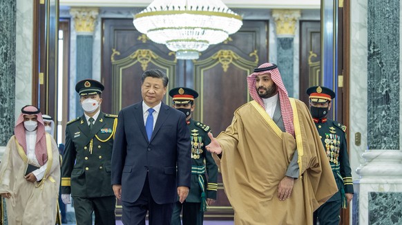 epa10354856 A handout photo made available by the Saudi Royal Court shows Saudi Crown Prince Mohammed bin Salman (R) welcoming Chinese President Xi Jinping (L) during his visit at Al Yamamah Palace in ...