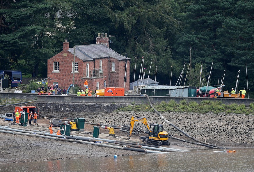 epa07756303 Engineers and members of the emergency services work to pump water from Toddbrook Reservoir, the spillway of which suffered severe damage following a period of heavy rainfall, above the to ...