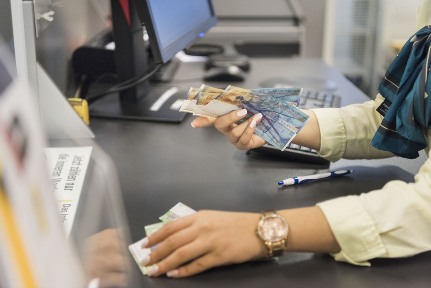 ARCHIVBILD ZUM WACHSTUM DER SCHWEIZER WIRTSCHAFT UM 0.3 PROZENT IM 2. QUARTAL, AM DIENSTAG, 5. SEPTEMBER 2017 - A retail trade apprentice of the Swiss Post counts money at the post office Basel 3 Spal ...