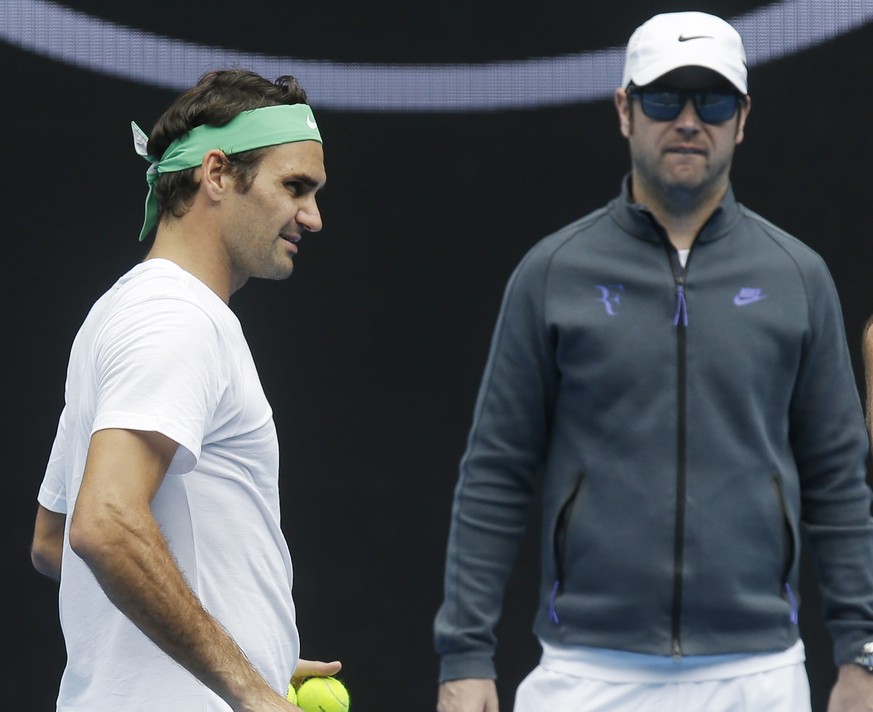 Switzerland&#039;s Roger Federer, left, talks with his coaches Ivan Ljubicic right, and Severin Luthi during a practice session ahead of the Australian Open tennis championships in Melbourne, Australi ...