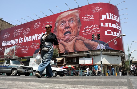 epa13135555 A woman walks past an anti-US and Trump billboard in a street in Tehran, Iran, 27 July 2026. The US and Iran paused strikes and retaliatory attacks to pursue diplomatic efforts to end the  ...