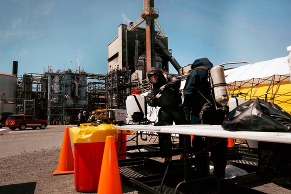 Soldiers and airmen from the Washington National Guard's 10th Homeland Response Force offer support to first responders following an implosion of a chemical tank at Nippon Dynawave pulp and paper ...