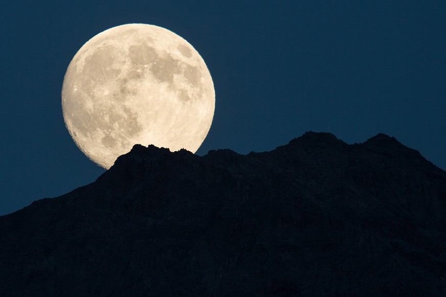 Der Perigaeums-Vollmond geht ueber der Mederger Flue oberhalb Langwies im buenderischen Schanfigg auf am Samstag, 9. August 2014. Im Durchschnitt tritt ein Perigaeums-Vollmond alle 13 Monate einmal au ...