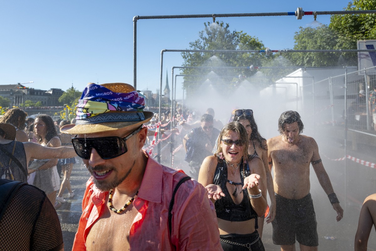 epa11543331 Participants of the 31st Street Parade cool off at a shower at the lake basin in Zurich, Switzerland, 10 August 2024. The annual dance music event Street Parade runs this year under the mo ...