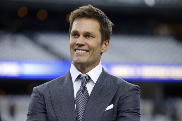 Fox Sports lead NFL analyst Tom Brady stands on the field during warmups before an NFL football game between the Detroit Lions and the Dallas Cowboys in Arlington, Texas, Sunday, Oct. 13, 2024. (AP Ph ...