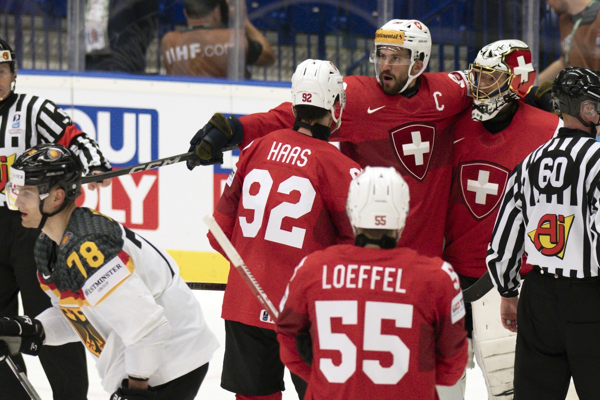 Switzerland's Gaetan Haas, Roman Josi and Goalkeeper Leonardo Genoni, from left, celebrate their victory during the Ice Hockey World Championship quarter final match between Switzerland and Germa ...