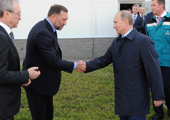 FILE - In this Sept. 19, 2014 file-pool photo, Russian President Vladimir Putin, right, shakes hands with Russian metals magnate Oleg Deripaska while visiting the RusVinyl plant in Kstovo, in Russia&# ...