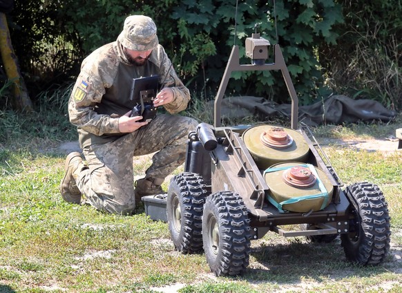 Serviceman Oleksandr call sign Ruf prepares a ground drone for the mining process during a meeting for the press to demonstrate all the main types of ground robotic systems used by Ukraine on the fron ...