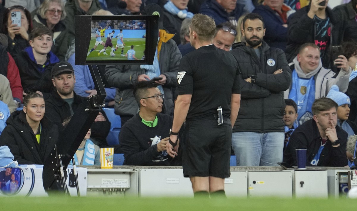 Referee Craig Pawson pauses the match and asks for the VAR to check on a possible goal during the English Premier League soccer match between Manchester City and Aston Villa at Etihad stadium in Manch ...