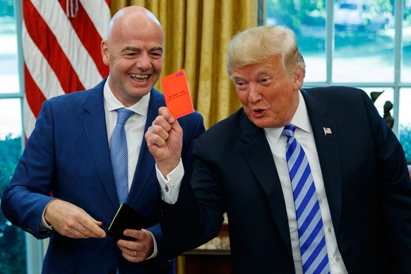 FILE - President Donald Trump holds up a red card during a meeting with FIFA president Gianni Infantino in the Oval Office of the White House, Tuesday, Aug. 28, 2018, in Washington. (AP Photo/Evan Vuc ...