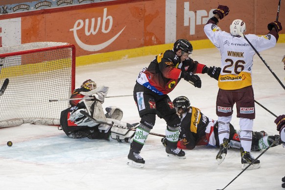 Berns Tomi Karhunen, Justin Krueger und Andre Heim, von links, geschlagen Servettes Daniel Winnik, rechts, jubelt, waehrend des Meisterschaftsspiels der National League zwischen dem SC Bern und dem Ge ...