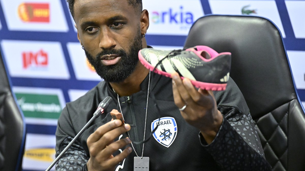 Israel team captain Eli Dasa shows a shoe of a kidnapped Israeli boy during a press conference, before a training session for the Euro 2024 group I qualifying soccer match between Israel and Switzerla ...