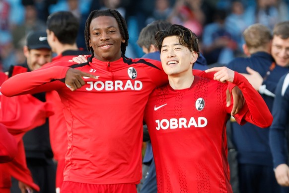 Freiburg's Johan Manzambi and his teammate Yuito Suzuki celebrate at the end of the Europa League quarterfinal second leg soccer match between Celta Vigo and Freiburg in Vigo, Spain, Thursday, Ap ...