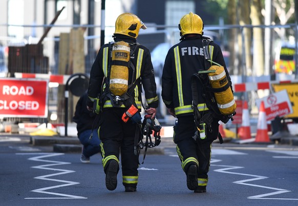 epa06027207 Firemen at a huge tower block fire in west London, Britain, 14 June 2017. According to the London Fire Brigade (LFB), 40 fire engines and 200 firefighters are working to put out the blaze. ...