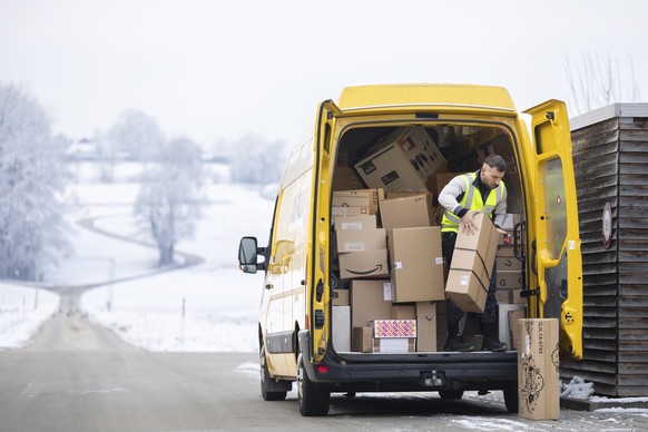 Der Paketbote der Schweizerischen Post Aron Moldovan liefert Pakete in der Region Frauenfeld, am Dienstag, 13. Dezember 2022 in Frauenfeld. Zwischen Black Friday und Weihnachten verarbeiten die Mitarb ...