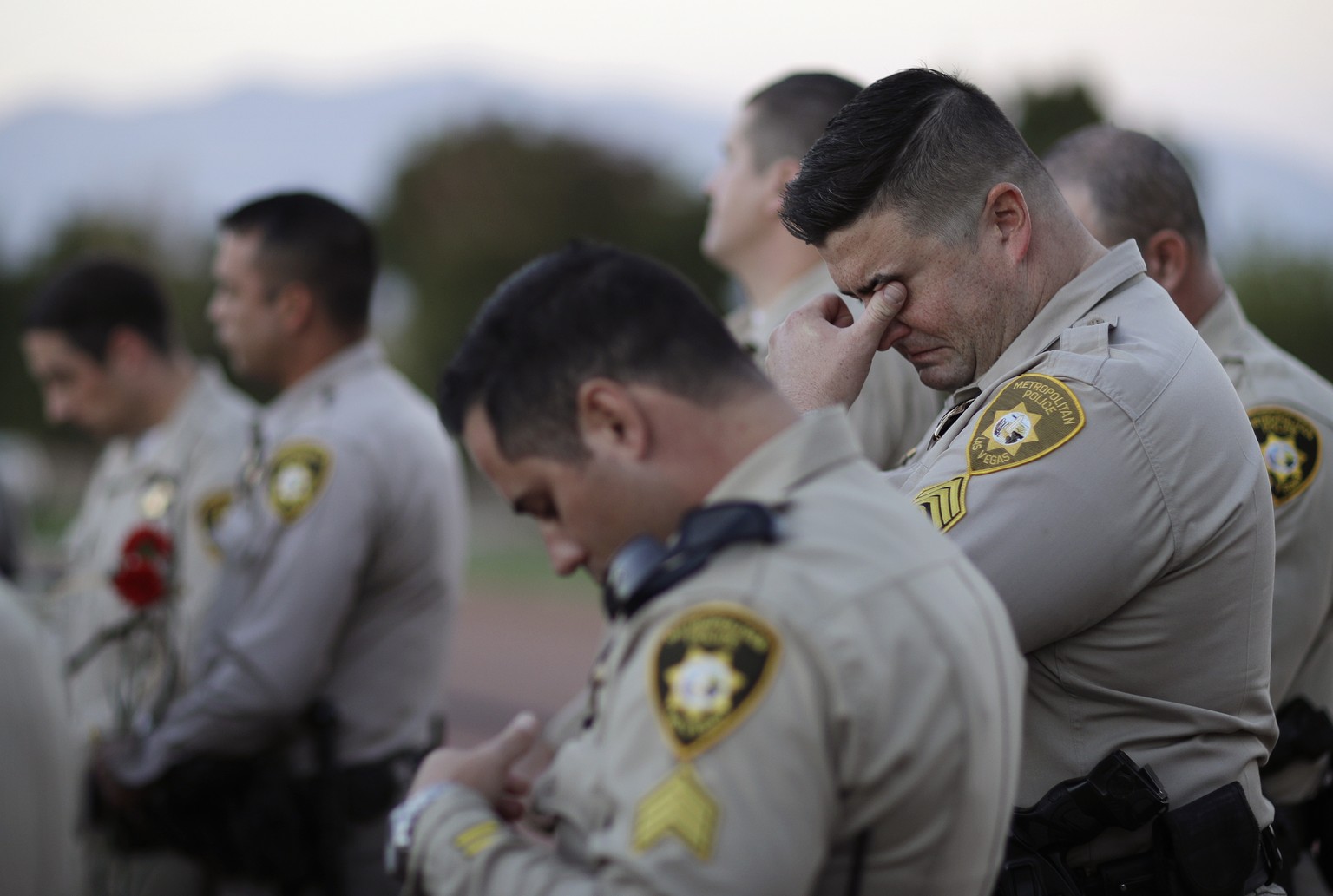 Las Vegas police Sgt. Ryan Fryman, right, wipes tears from his eyes during a vigil for Las Vegas police officer Charleston Hartfield, Thursday, Oct. 5, 2017, in Las Vegas. Hartfield was killed when St ...