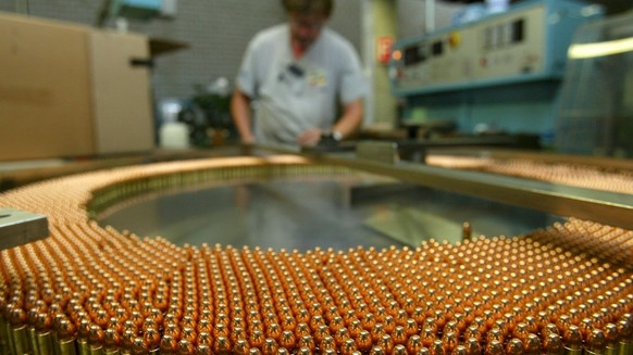 Ein Arbeiter kontrolliert am Donnerstag, 25. Juli 2002 in Thun in der Munitionsabteilung des Ruestungskonzerns Ruag, der Ruag Munition, die Herstellung von 9-Millimeter-Patronen. Ruag International ha ...