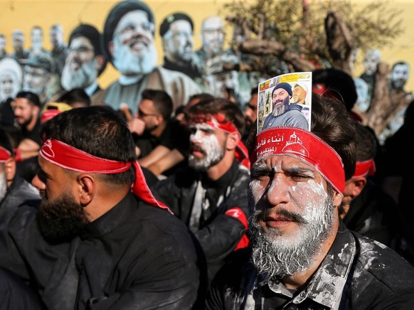 June 26, 2026, Beirut, Beirut, Lebanon: Pro-Iranian Hezbollah supporters sit in front of a poster of party leaders assassinated by Israel in Beirut southern suburb as they mourn during the last day of ...