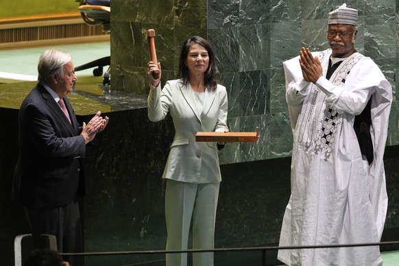 Secretary-General António Guterres, left, and former president of the General Assembly Philemon Yang, right, look on, as Annalena Baerbock, center, holds up a gavel after being sworn in as the preside ...