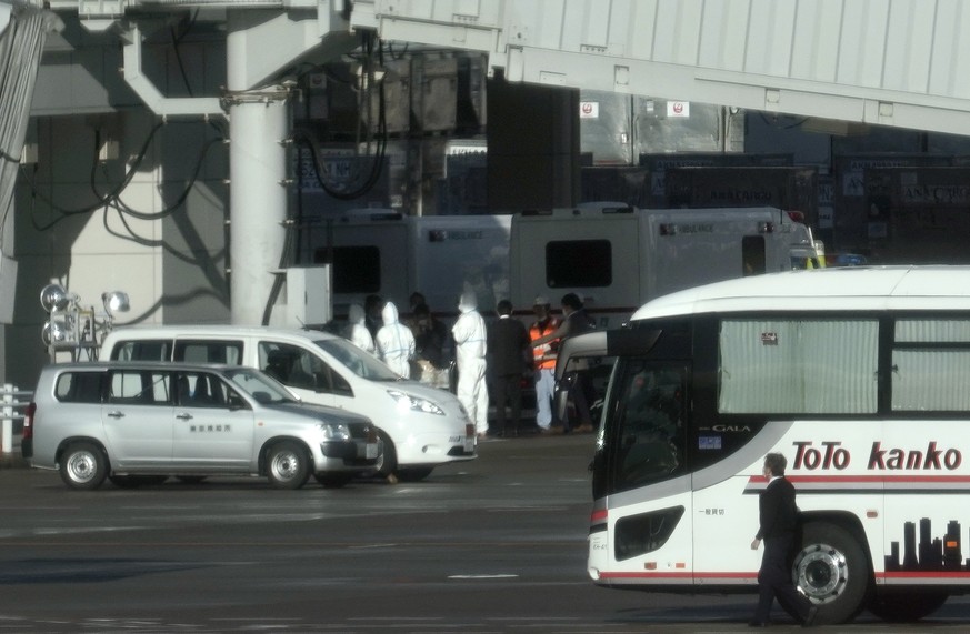 epa08174201 Tokyo quarantine officers wearing full protective gear prepare near a charted flight, believed to be carrying Japanese nationals repatriated from Wuhan, at Haneda airport in Tokyo, Japan,  ...