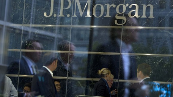 Workers are reflected in the windows of the Canary Wharf offices of JP Morgan in London, in this file photo taken September 19, 2013. JPMorgan Chase &amp; Co, the biggest U.S. bank by assets, reported ...