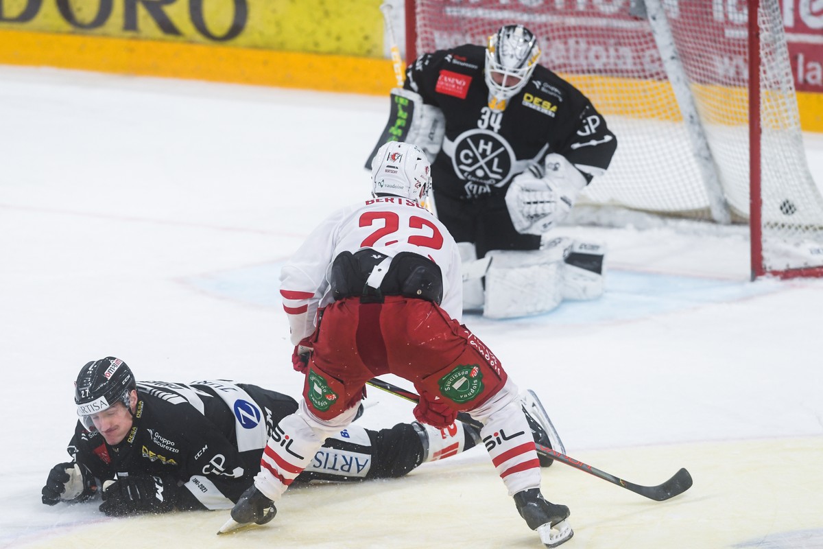 From right, Lausanne's player Christoph Bertschy scores the 1-3 goal against Lugano?s goalkeeper Niklas Schlegel, during the preliminary round game of National League A (NLA) Swiss Championship 2 ...