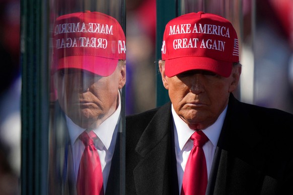Republican presidential nominee former President Donald Trump is reflected in the bullet proof glass as he finishes speaking at a campaign rally in Lititz, Pa., Sunday, Nov. 3, 2024. (AP Photo/Matt Ro ...