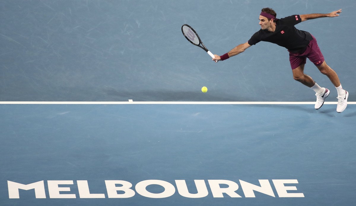 Switzerland's Roger Federer attempts to make a backhand return to Serbia's Novak Djokovic during their semifinal match at the Australian Open tennis championship in Melbourne, Australia, Thu ...