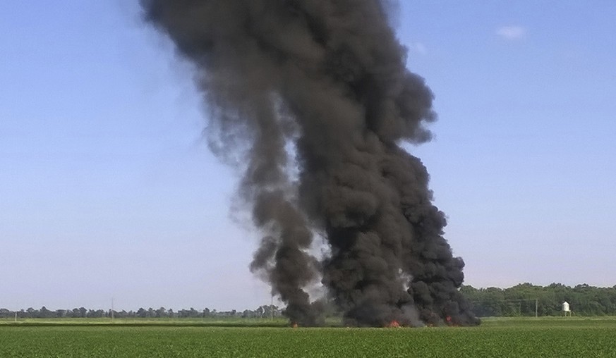 In this photo provided by Jimmy Taylor, smoke and flames rise into the air after a military transport airplane crashed in a field near Itta Bena, Miss., on the western edge of Leflore County, Monday,  ...