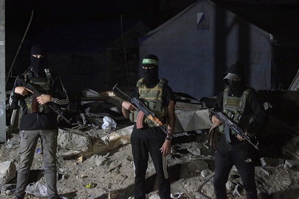 epa12456504 Palestinian fighters from Hamas&#039;s Izz ad-Din al-Qassam Brigades guards as vehicles of the International Committee of the Red Cross (ICRC) arrive to transport remains of Israeli hostag ...