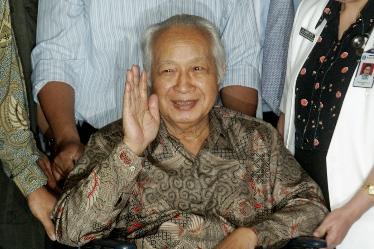 FILE - Former Indonesian President Suharto waves to journalists as he leaves a hospital after being treated for intestinal bleeding, in Jakarta, Indonesia, on May 5, 2004. (AP Photo/Dita Alangkara, Fi ...